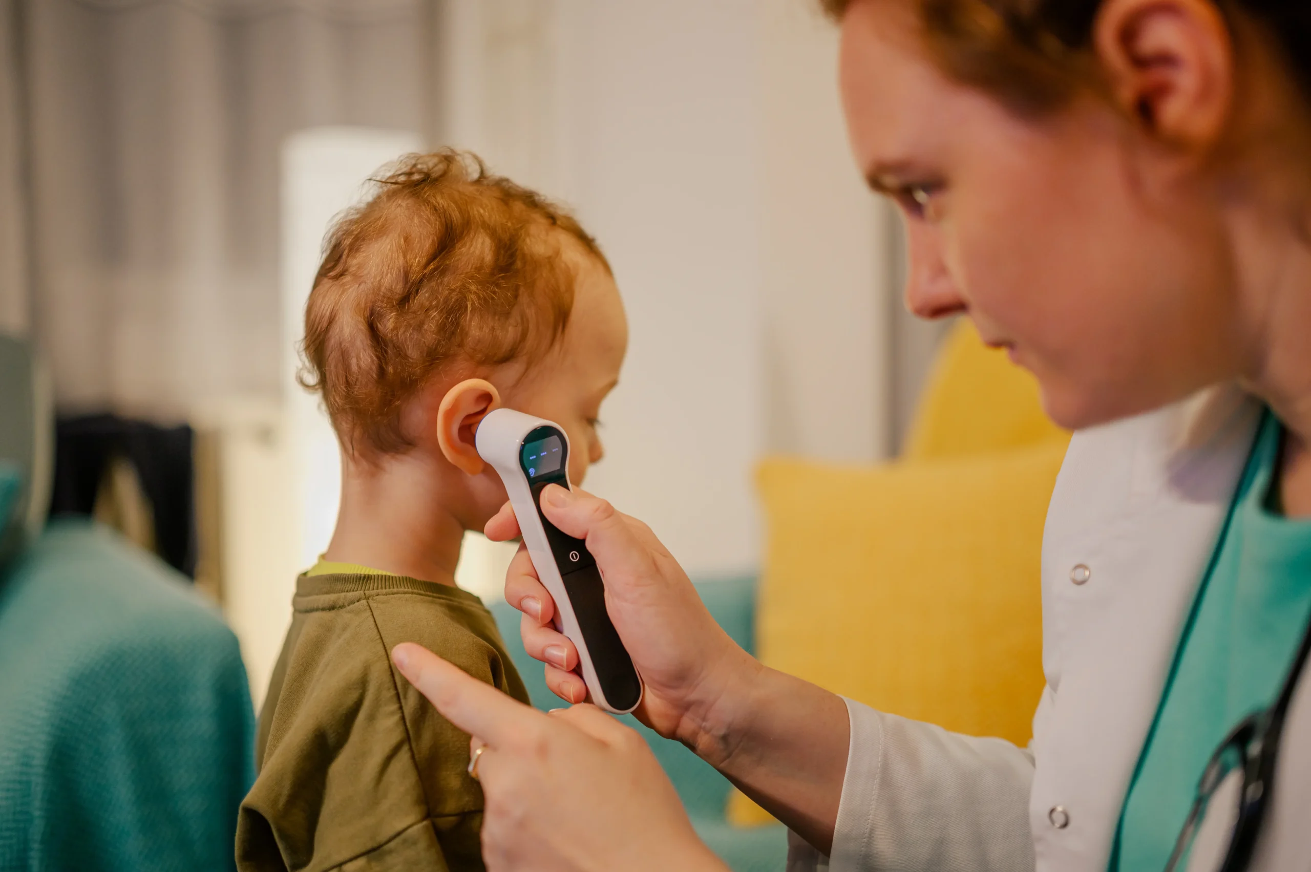 A pediatrician is measuring temperature during her home visit. - How to Prevent Ear Infections in Newborns: A Complete Guide for Parents - Kare One NICU Care Support Family