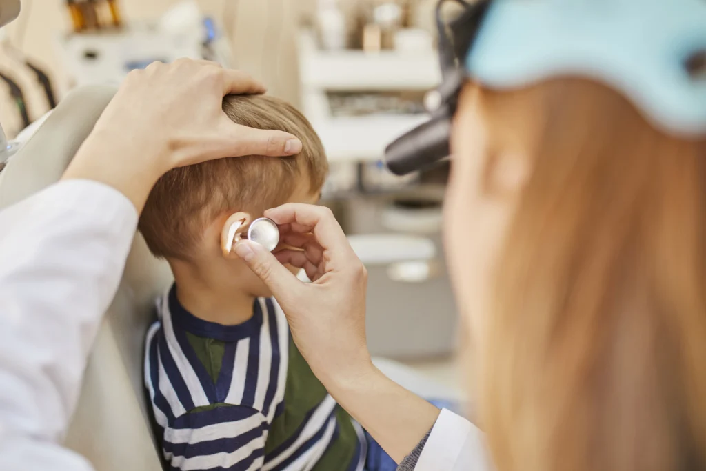 ENT physician examining ear of a boy - Kare One NICU Care Support Family