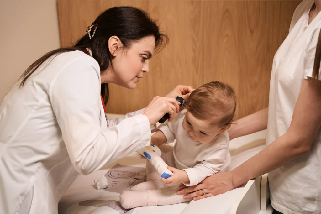 Experienced otolaryngologist examining eardrum of little baby - Kare One NICU Care Support Family