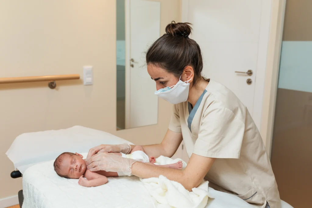 Female physiotherapist working with a newborn baby in a medical center - Neonatal Opioid Withdrawal Syndrome: Causes, Symptoms, and Treatment - A Complete Guide - Kare One NICU Care