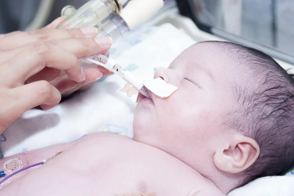 Portrait Of Newborn Baby And Hand Inside Incubator - Neonatal Opioid Withdrawal Syndrome: Causes, Symptoms, and Treatment - A Complete Guide - Kare One NICU Care